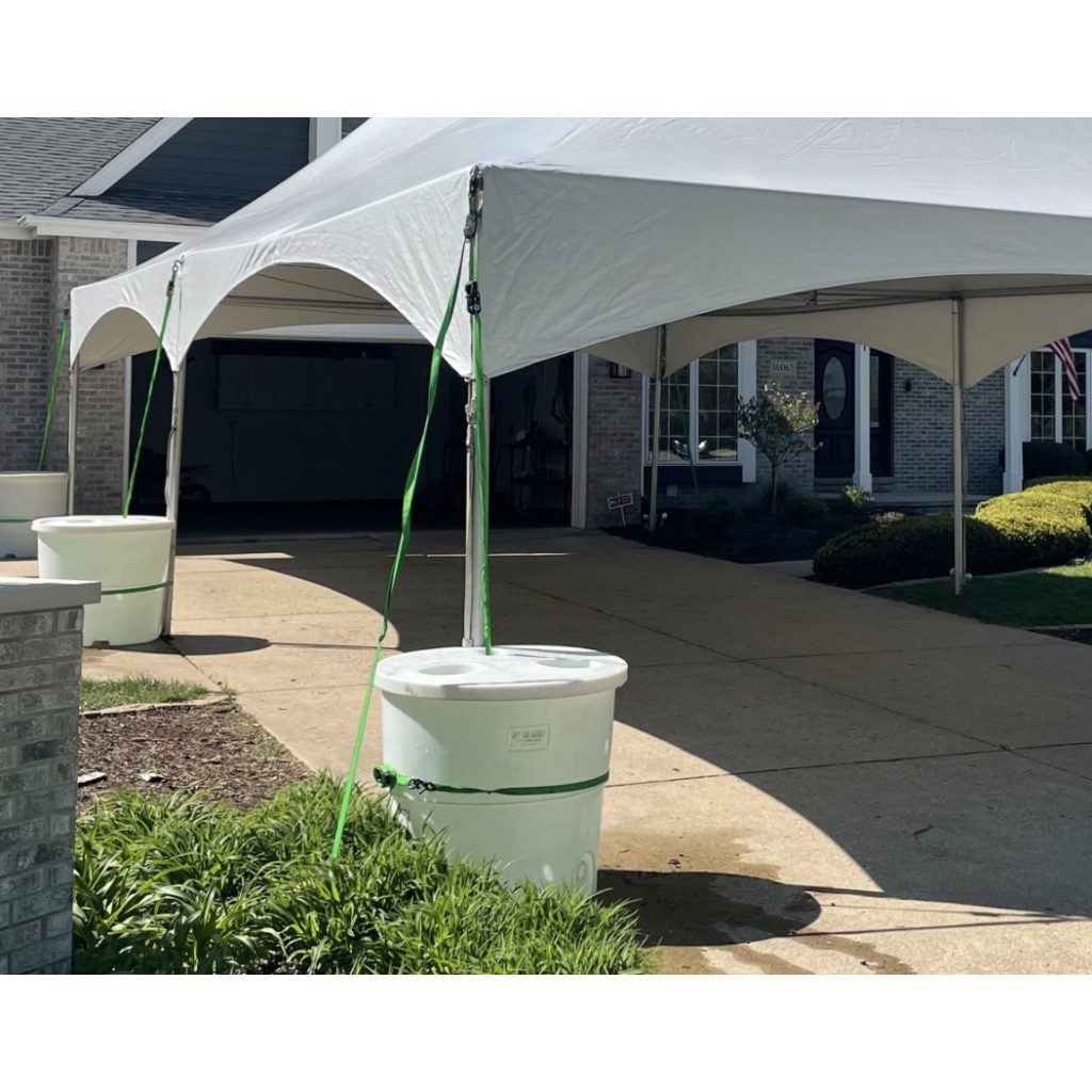 tent anchored with water barrels